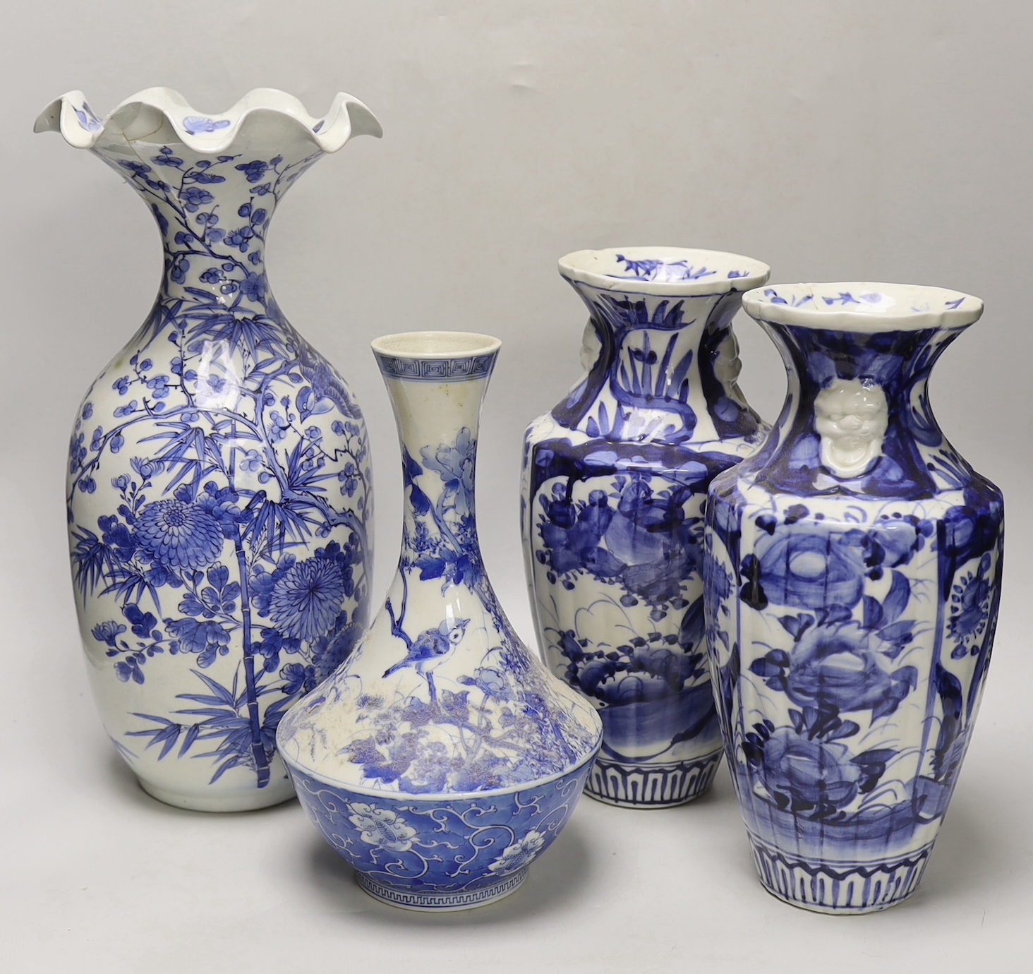 A pair of Japanese blue and white birds and flowers pattern vases and two other vases, tallest 39cm high